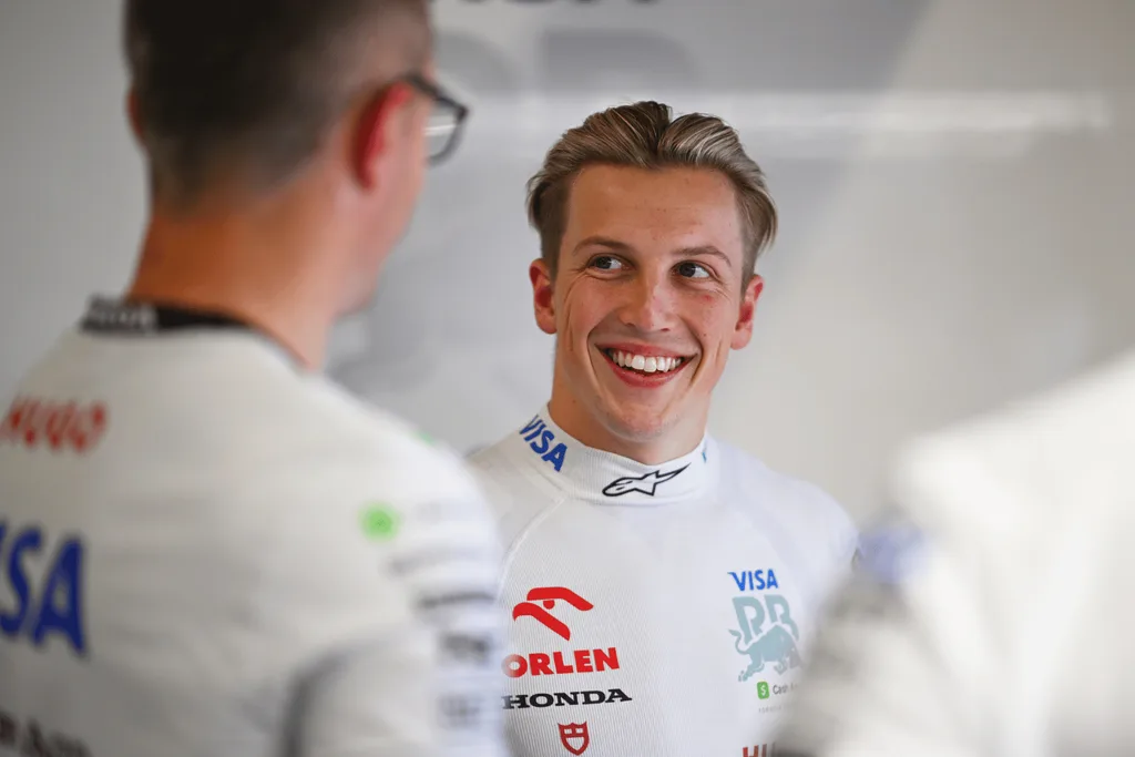 Liam Lawson speaking with an engineer.