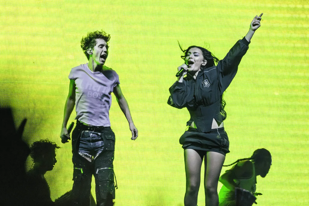 Troye Sivan and Charli XCX performing in front of neon green backdrop