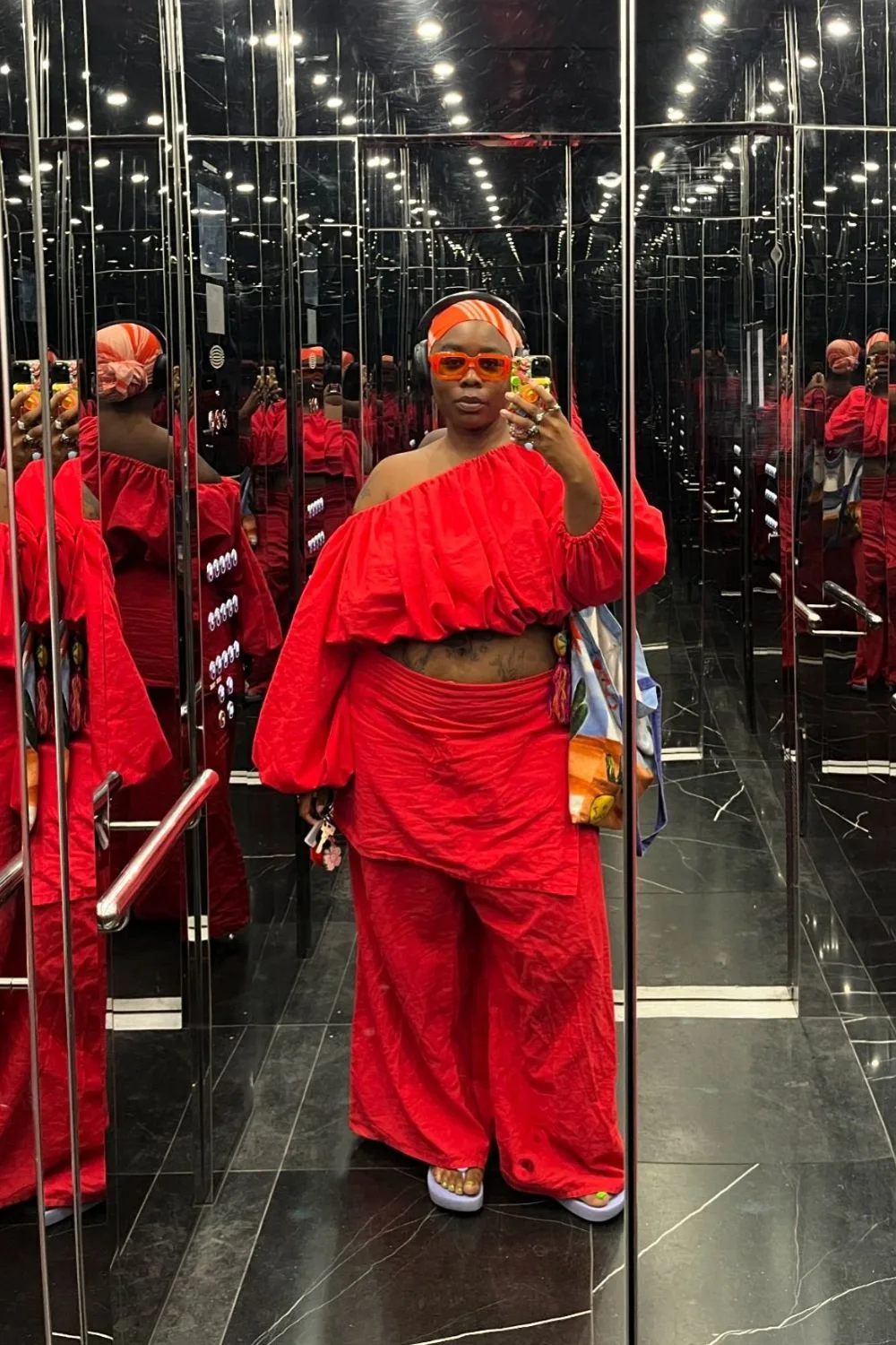 Flex Mami wearing all read in a mirror selfie. 