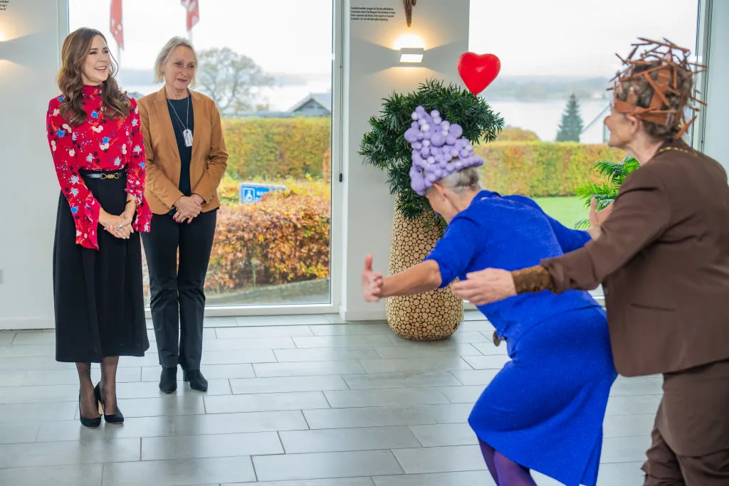 The clowns greet Mary with a curtsy