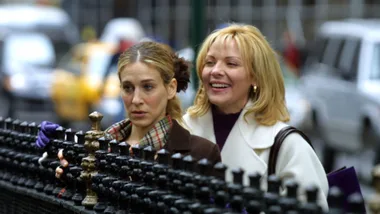 Samantha and Carrie from Sex and the City looking over a fence