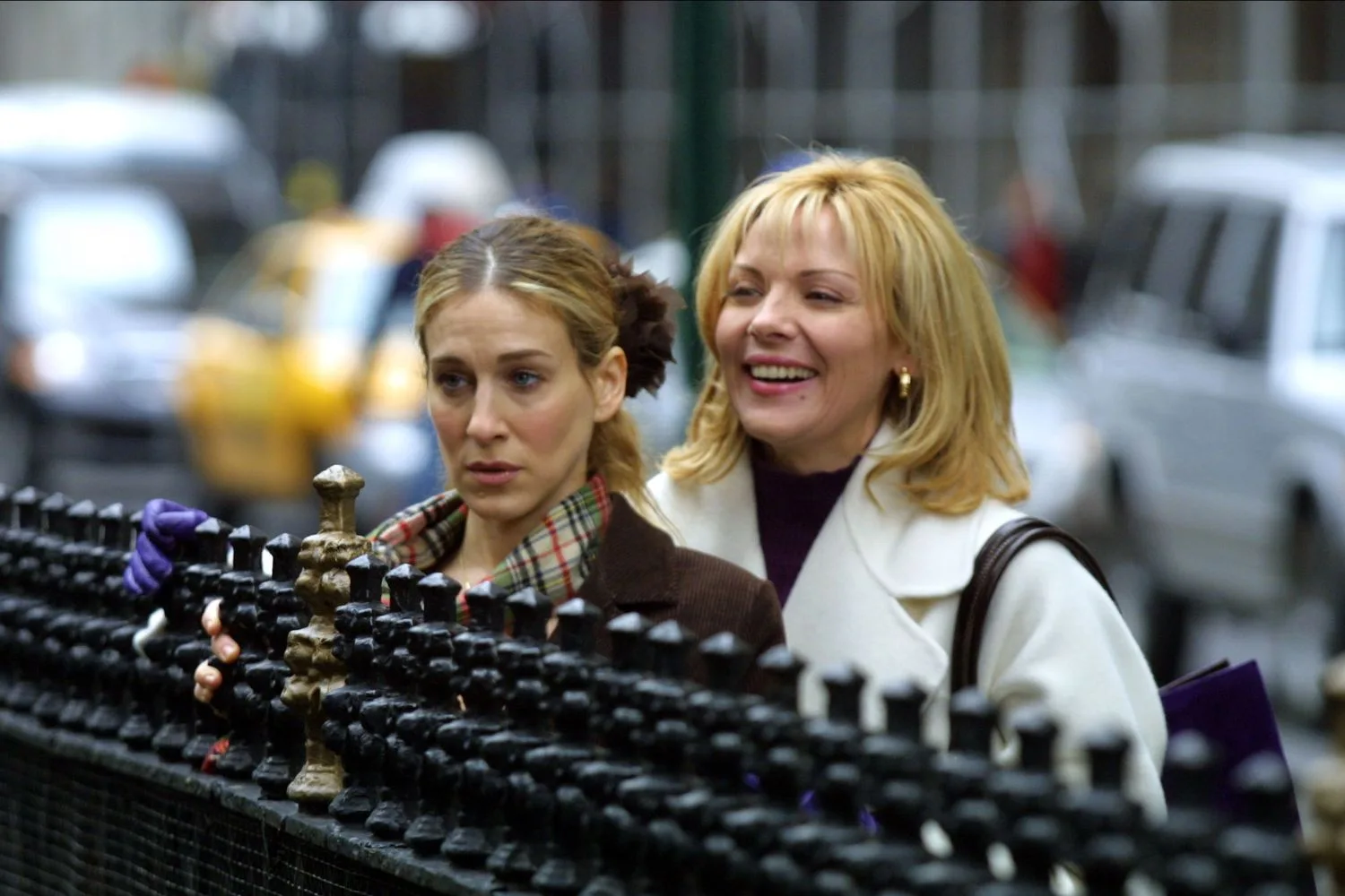 Samantha and Carrie from Sex and the City looking over a fence