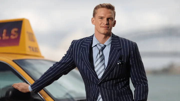 Cody Simpson standing against a yellow taxi