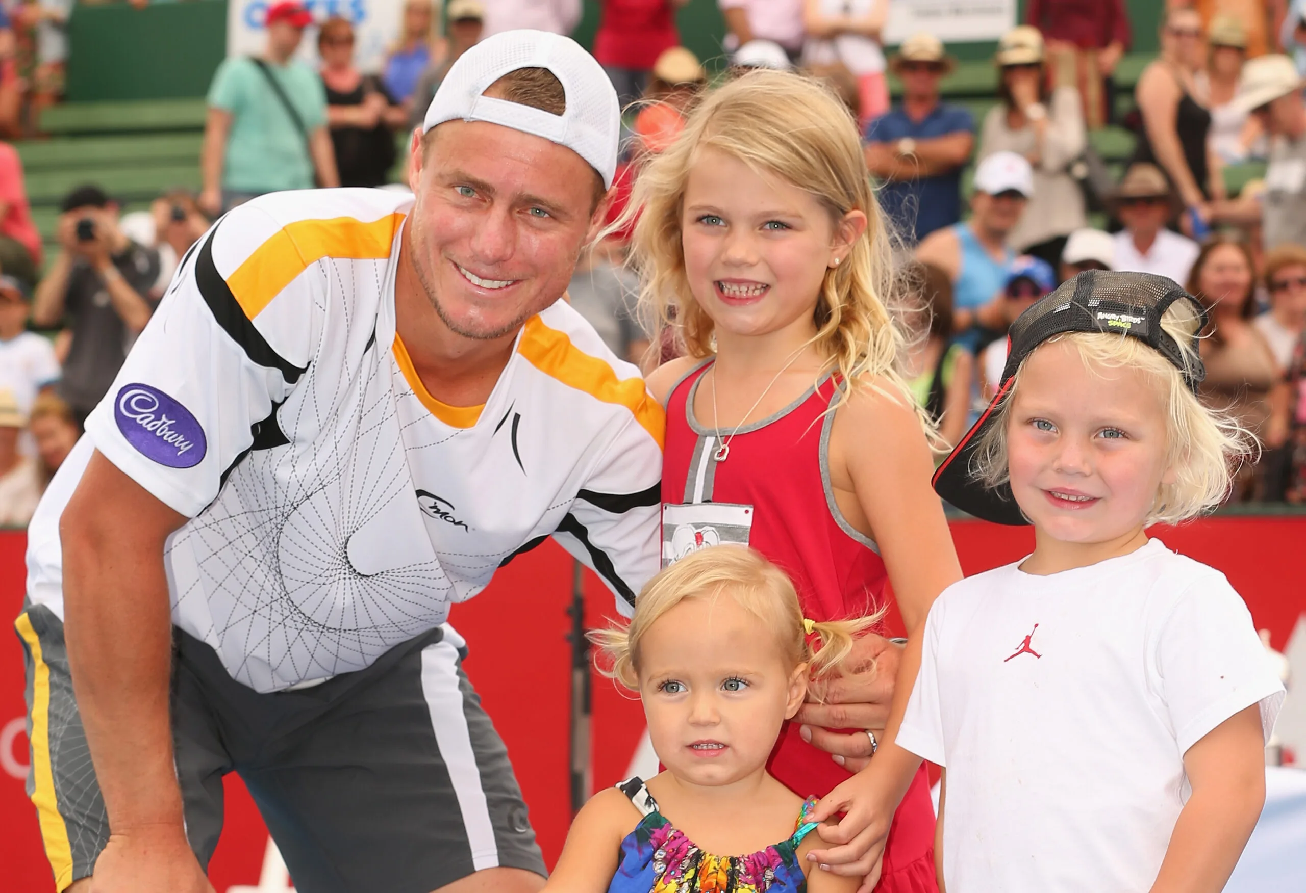 Lleyton Hewitt of Australia poses with the winners trophy and his children Ava Hewitt, Cruz Hewitt and Mia Hewitt after winning his match against Juan Martín del Potro of Argentina during day four of the AAMI Classic at Kooyong on January 12, 2013 in Melbourne, Australia. 