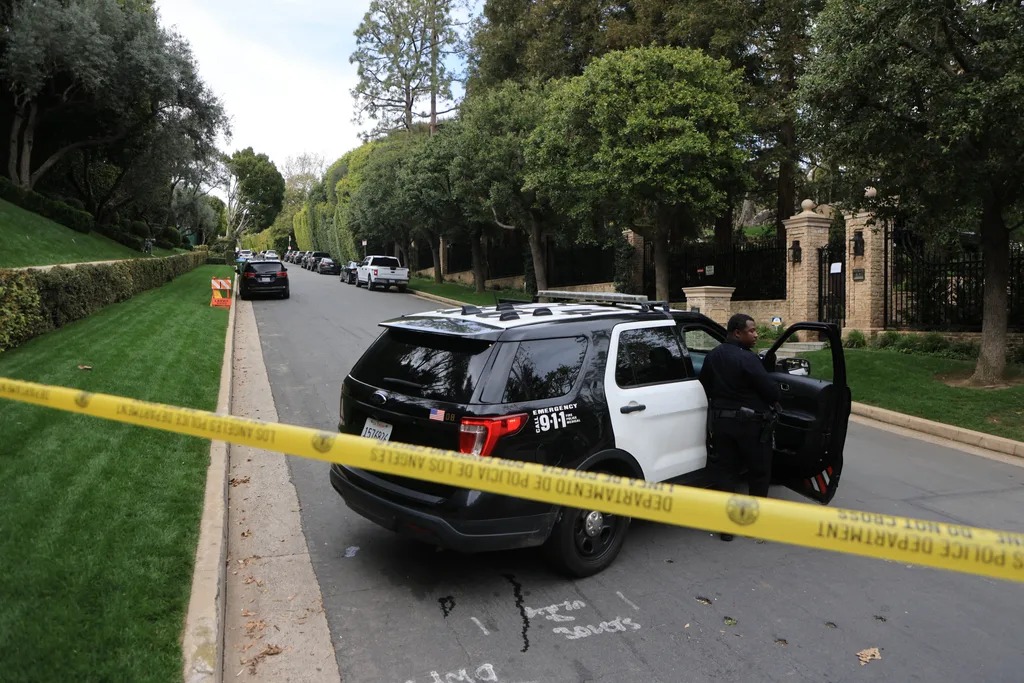 Police cars are seen behind caution tape outside the home of US producer and musician Sean "Diddy" Combs in Los Angeles on March 25, 2024. Homes belonging to Sean "Diddy" Combs were being raided by federal agents, media reported on March 25, with the US hip hop mogul at the centre of sex trafficking and sex assault lawsuits.