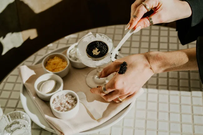Someone spooning caviar onto their hand