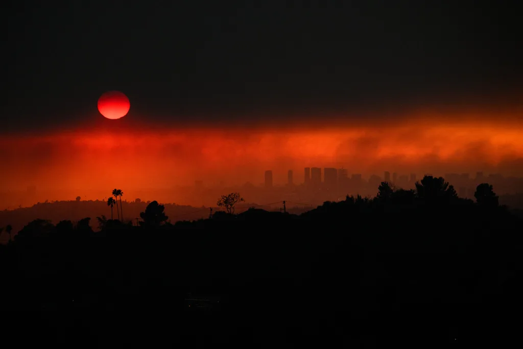 TOPSHOT - An aerial image shows smoke from wildfires including the Eaton Fire and Palisades Fire in Los Angeles, California, on January 8, 2025. At least five people have been killed in wildfires rampaging around Los Angeles, officials said on January 8, with firefighters overwhelmed by the speed and ferocity of multiple blazes. (Photo by Patrick T. Fallon / AFP) (Photo by PATRICK T. FALLON/AFP via Getty Images)