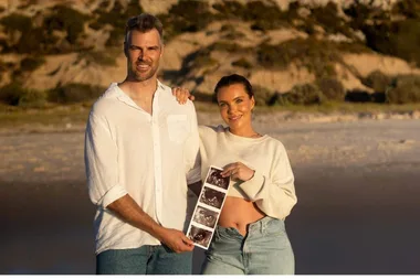 Keegan Brooksby and Abbey Holmes hold ultrasound scans of their baby