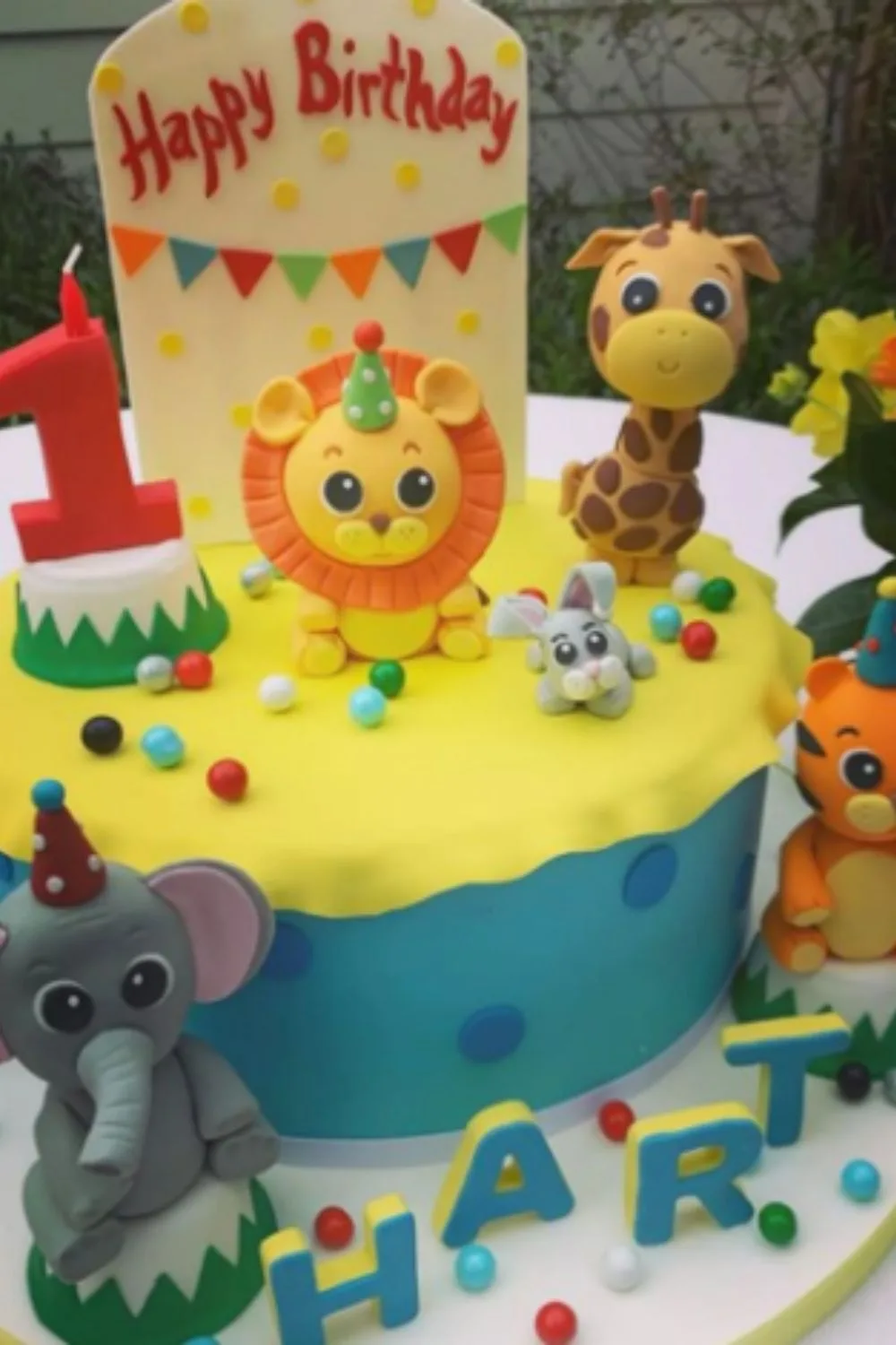 An elaborate first birthday cake with baby jungle animals on it for Hart Spiegle