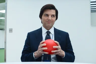 Adam Scott holds a red ball in a scene from Severance