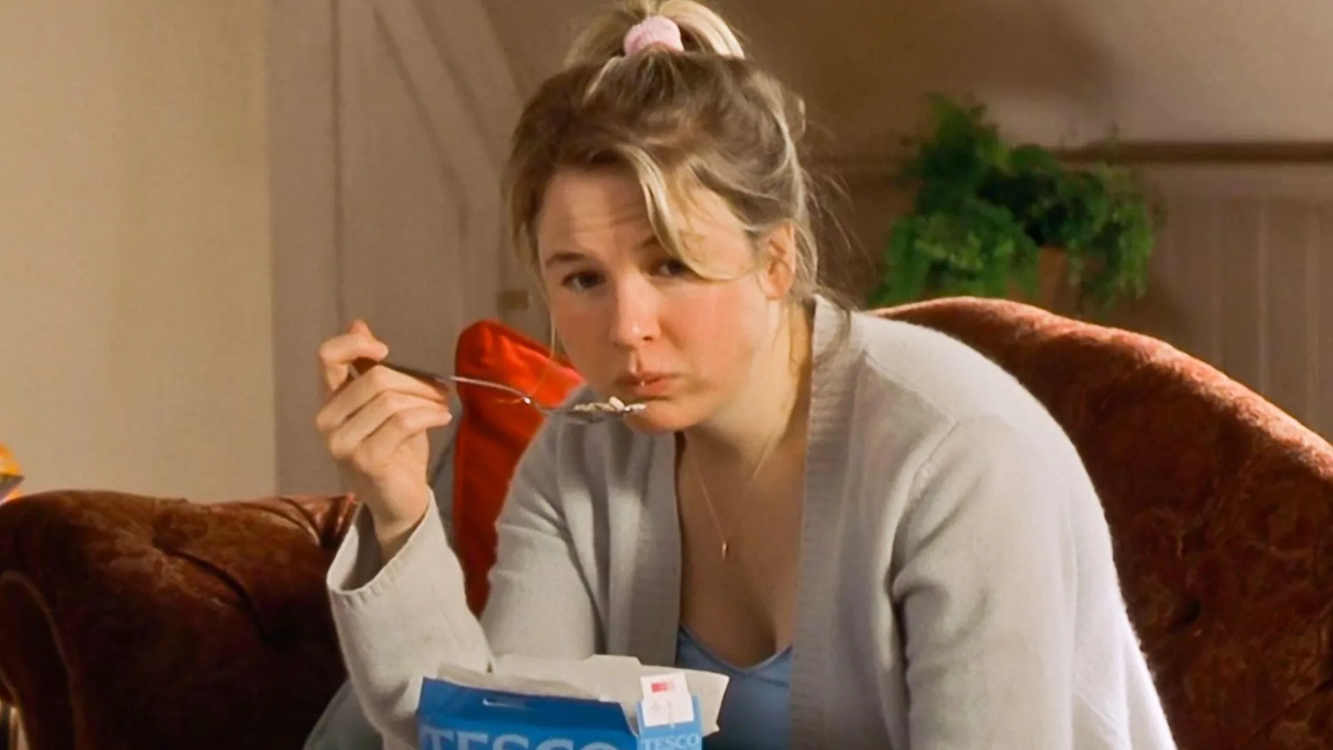 Bridget Jones eating cereal on her couch.