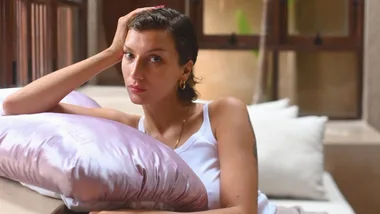 Woman leans on pink pillow