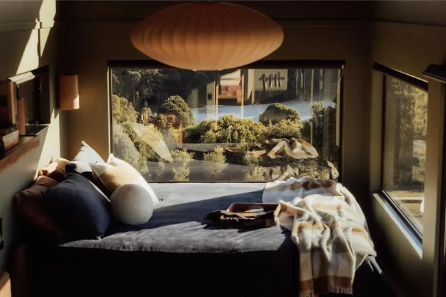Candlebark Ridge Tiny Home grey queen bed overlooking greenery