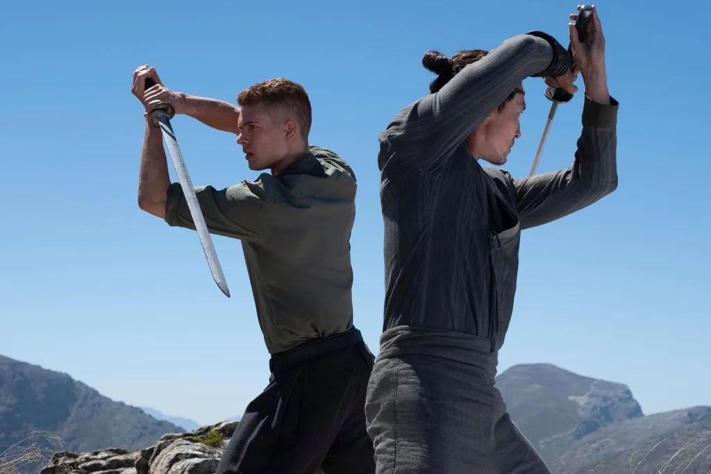 Two men with swords stand back to back in Wheel of Time S3 still