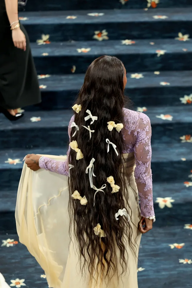 Sha'Carri Richardson with her back to the camera showing long black hair with small hair bows.