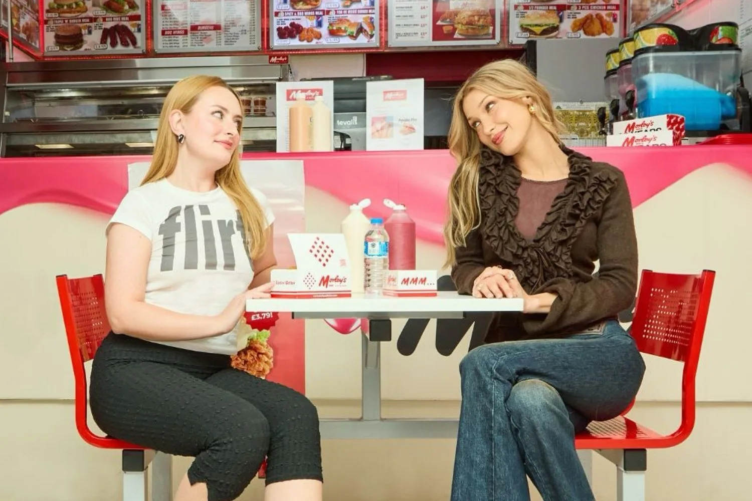 Model Bella Hadid being interviewed by Amelia Dimoldenberg at a chicken shop table