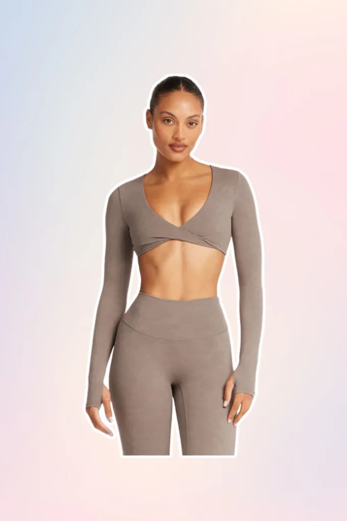 Light brown Pilates activewear cropped long sleeve top.