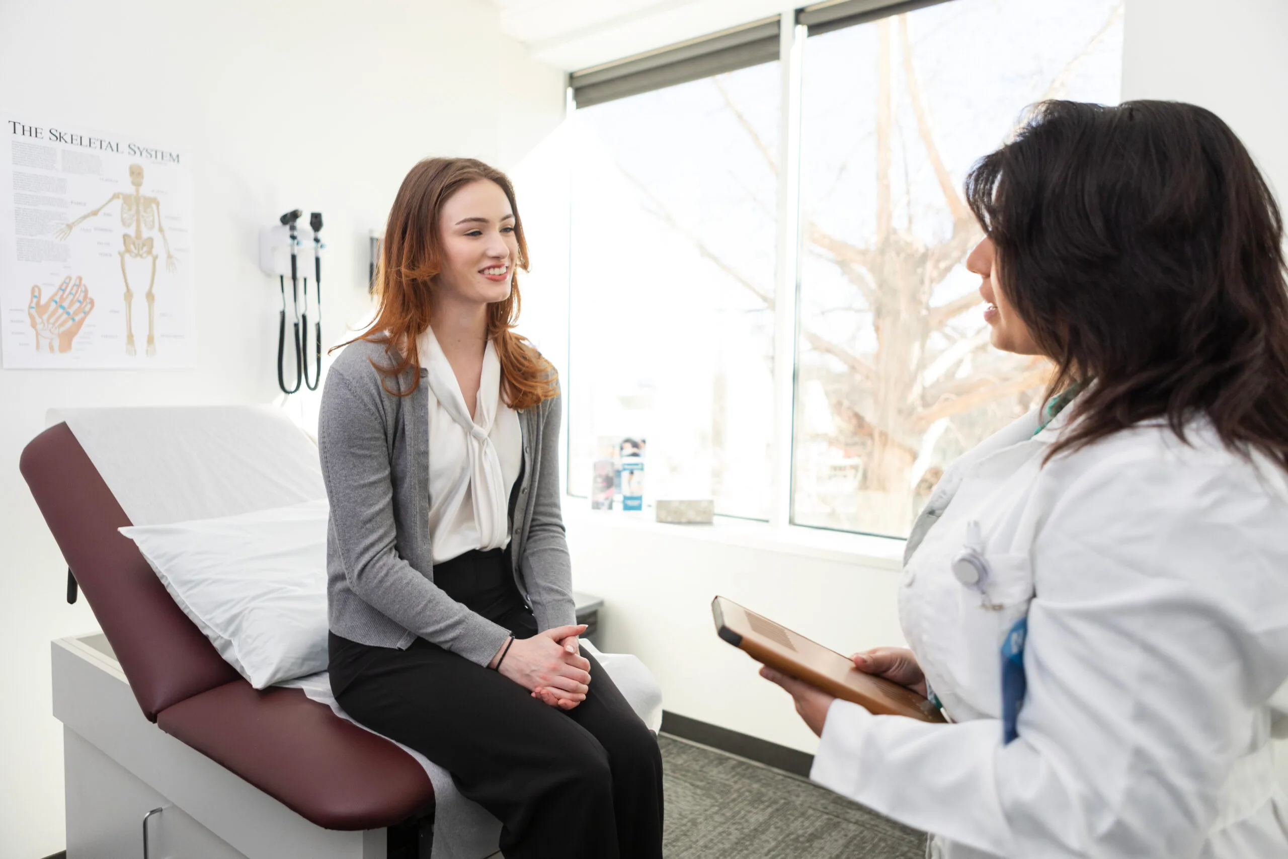 freezing eggs - young woman sitting on examination listening to a doctor