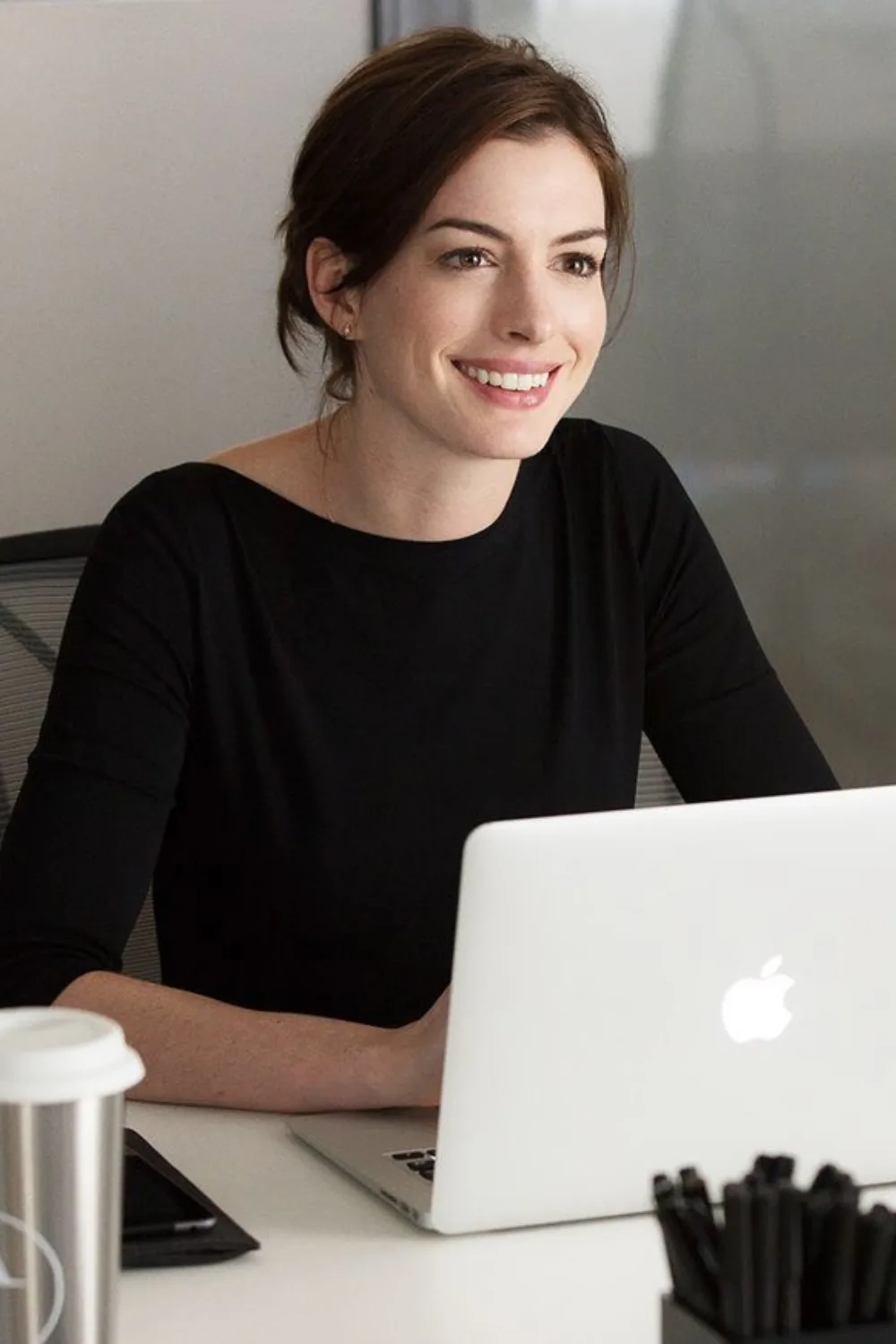 woman smiling while on her laptop