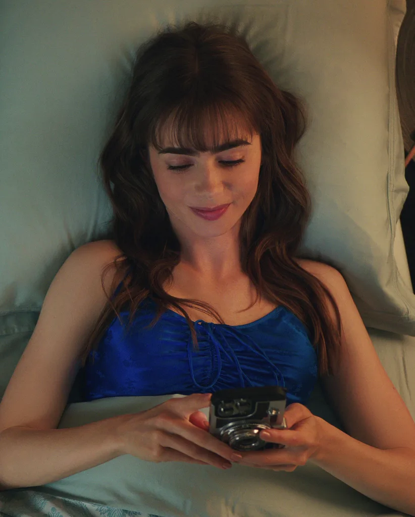 Woman in bed smiling at her phone. Not using ChatGPT for therapy.