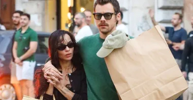 harry styles and zoe kravitz embracing while walking down the street with groceries