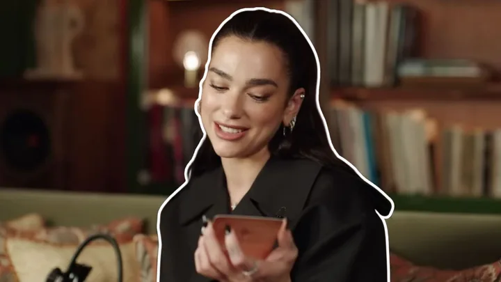 Dua Lipa holding a tarot card for Vogue's YouTube channel