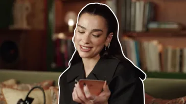 Dua Lipa holding a tarot card for Vogue's YouTube channel