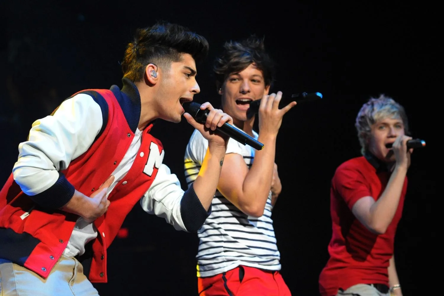 zayn and louis on stage singing alongside niall