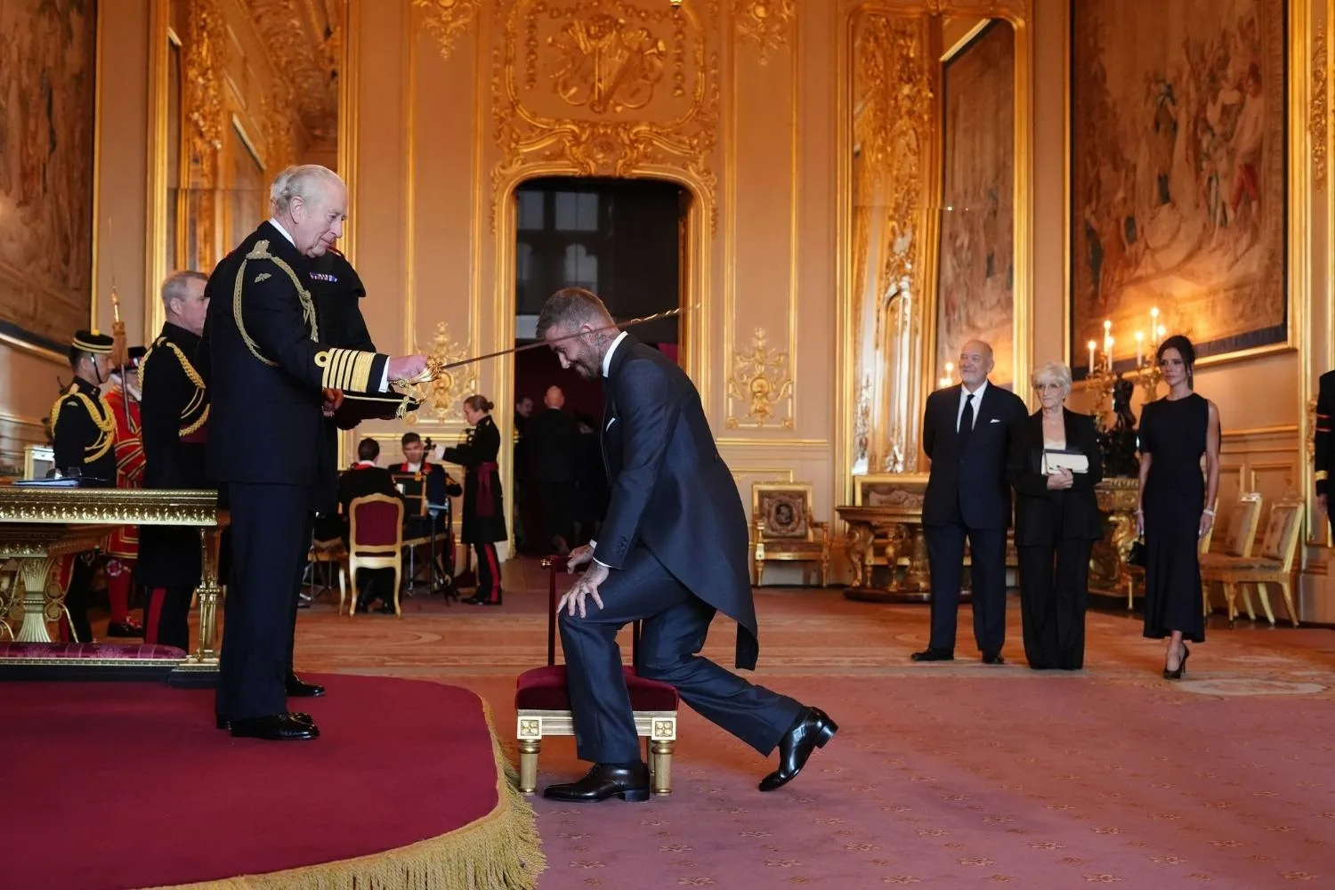 David Beckham being knighted by King Charles 