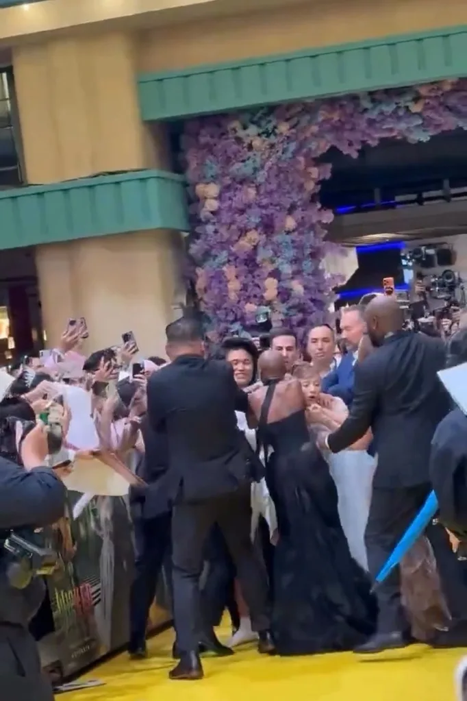 a screengrab of security tackling a man away from ariana grande