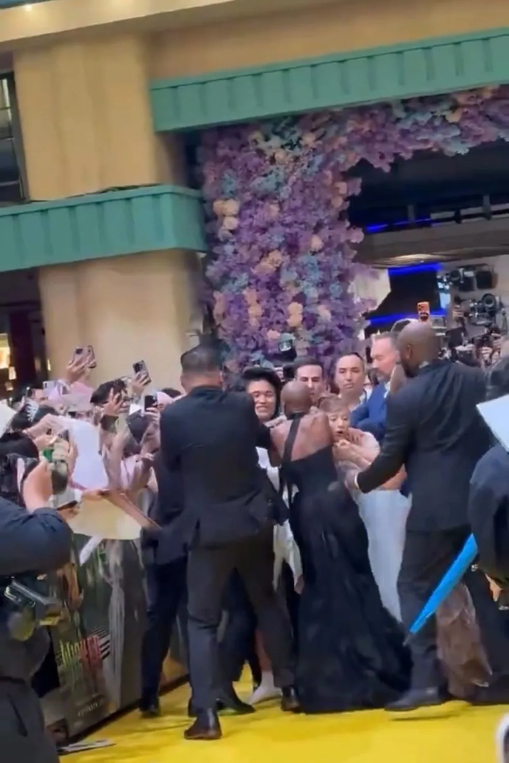 a screengrab of security tackling a man away from ariana grande