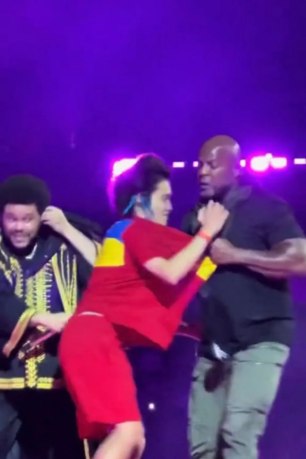 footage of a fan being taken away on stage by security next to the weeknd