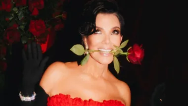 kris jenner glammed up with a rose in her mouth and in a red dress
