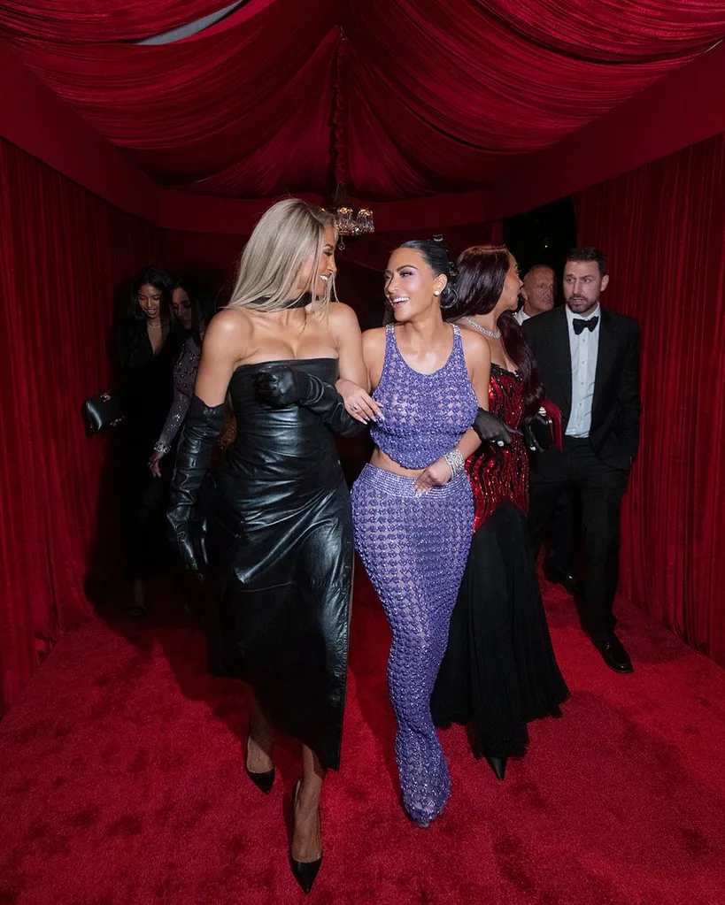 kim kardashian laughing and smiling with her arm interlocked with ciara