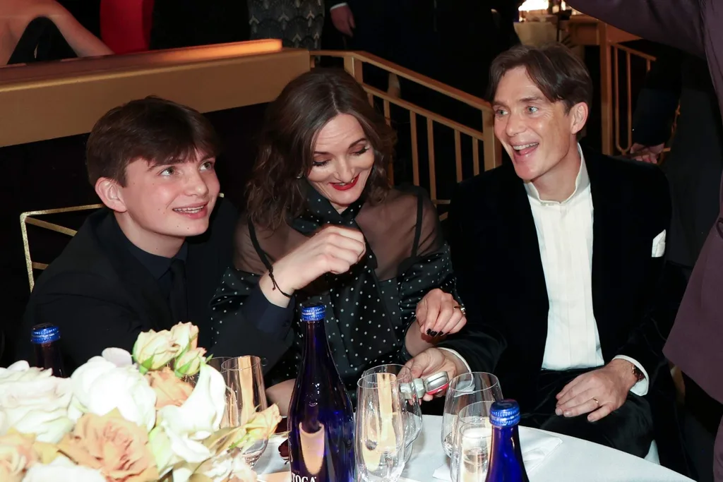 aran murphy posing for a photo with his parents at a table for an event