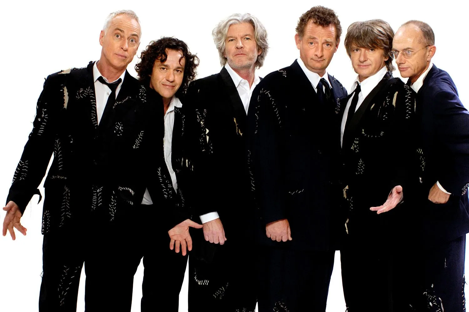 split enz members in black suits against a white background
