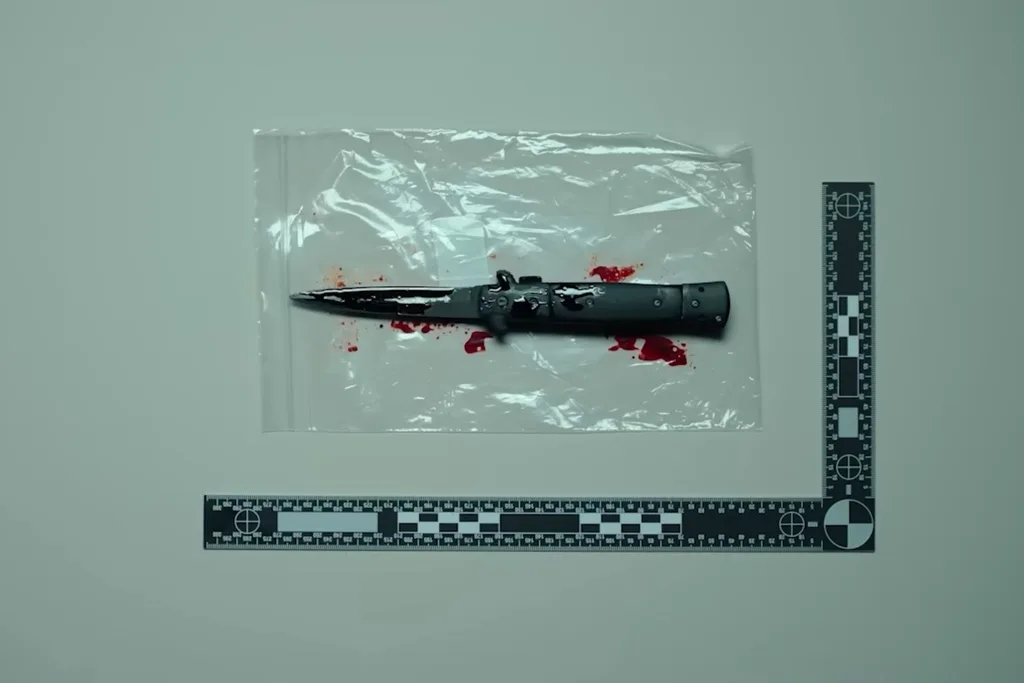 switchblade knife with blood in a clear plastic bag in a forensic photo