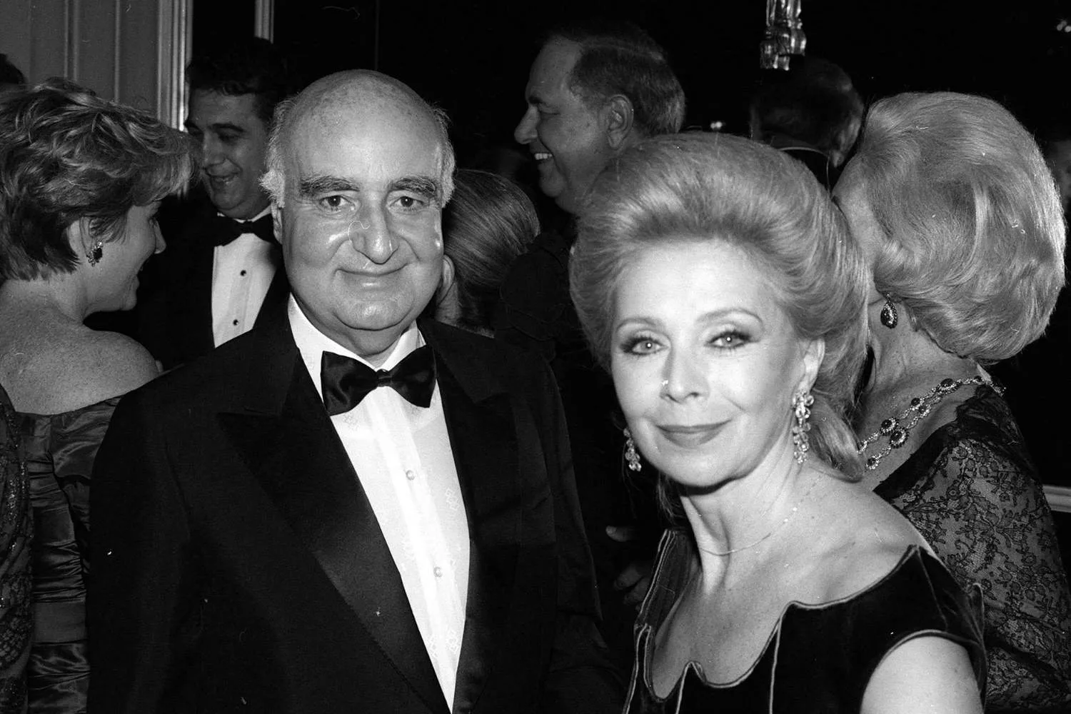 an older man and woman dressed formally for an event posing for a picture