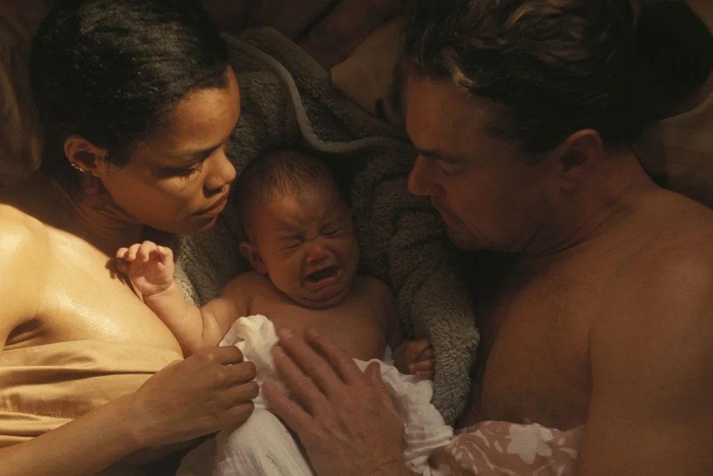 two parents with their baby in bed
