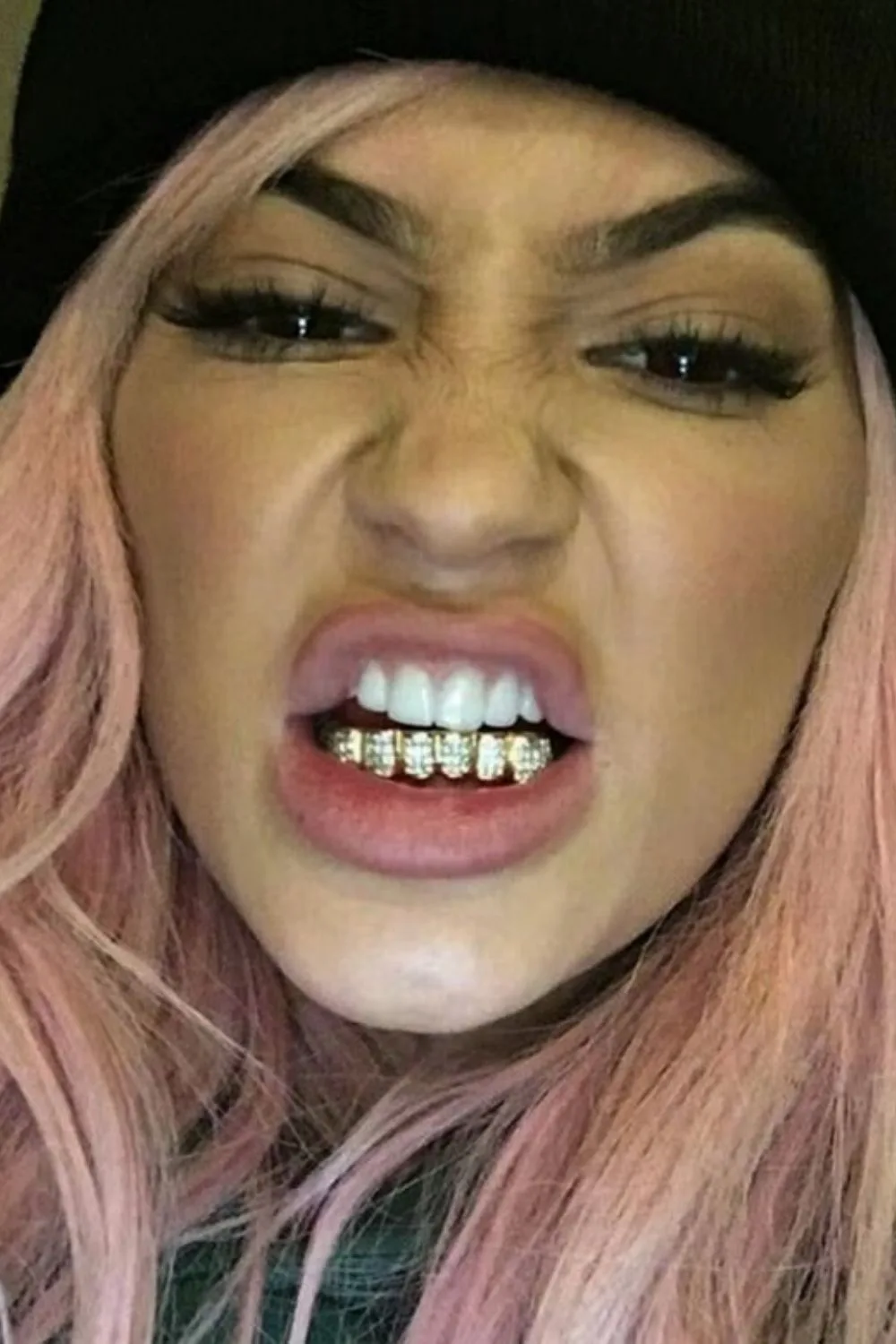 Kylie Jenner makes a face to the camera while sporting pink hair.