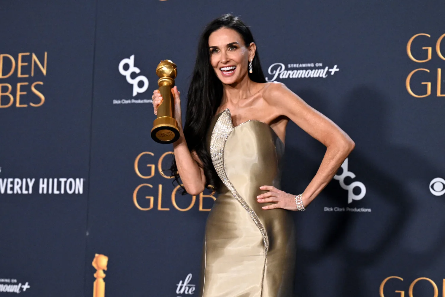Demi Moore holds a Golden Globe statuette. 
