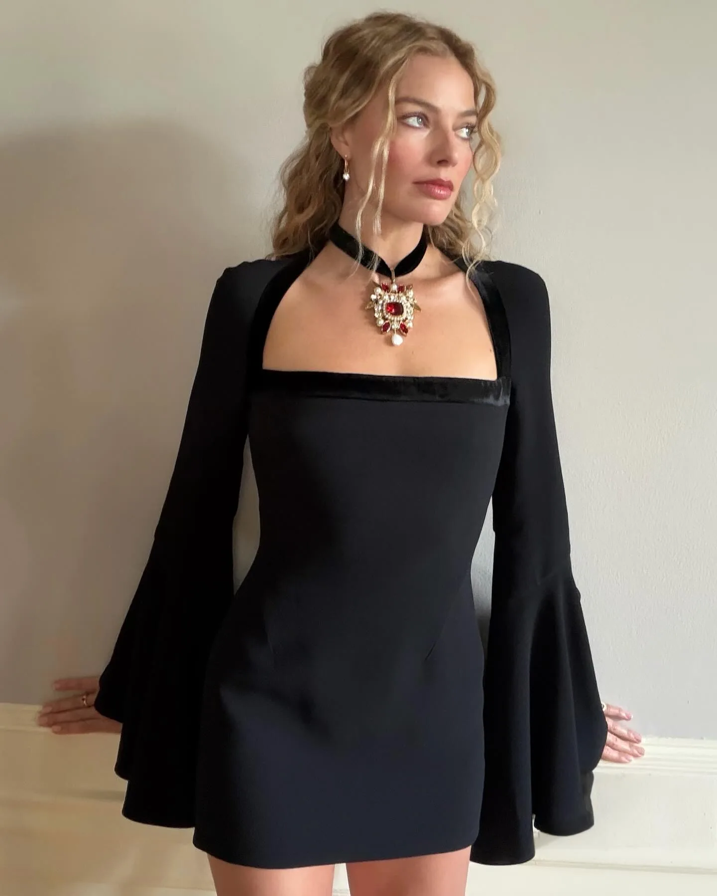 Margot Robbie in a black square neck dress. 