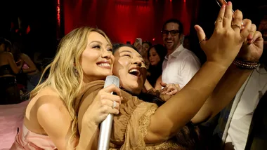 Hilary Duff singing with a fan.