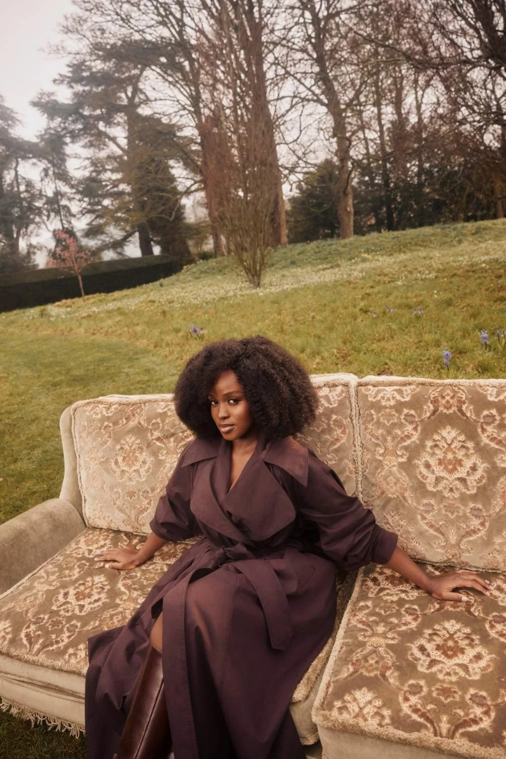 Masali Baduza on a couch on a lush grass lawn