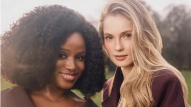 two women posed together on a lawn