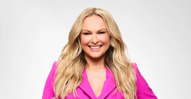 mel schilling smiling at the camera in a hot pink suit