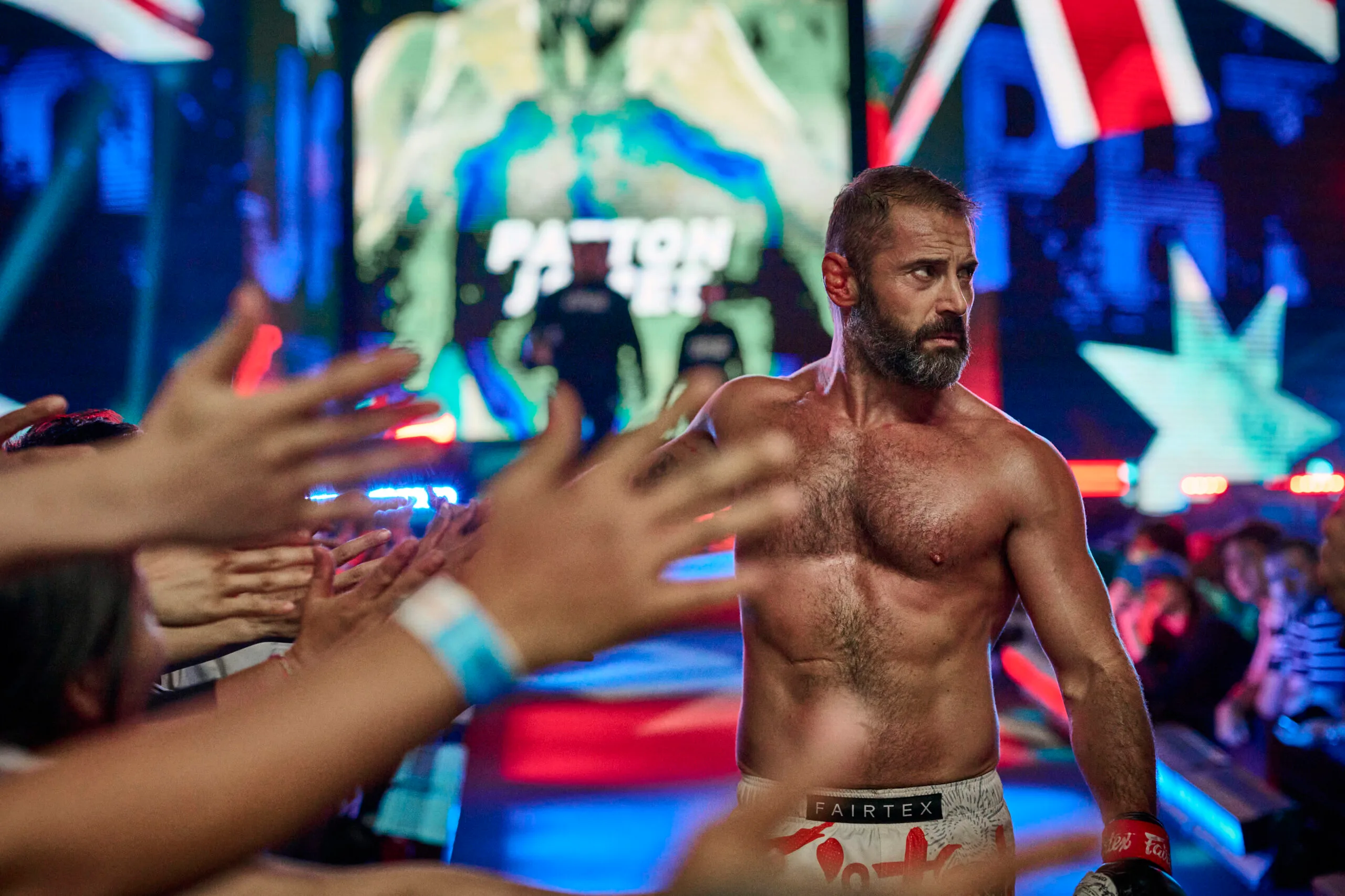 Daniel MacPherson shirtless in character for Beast as he walks out into the MMA fighting ring