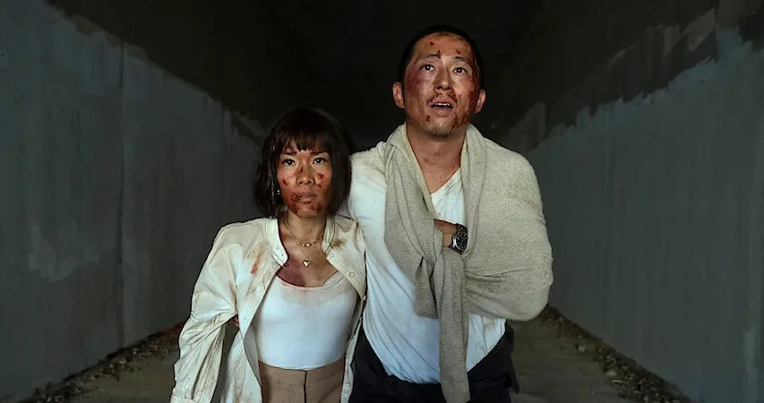 a man and woman walking with blood on them