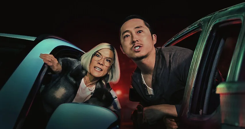 a man and woman leaning out of their car windows looking angry
