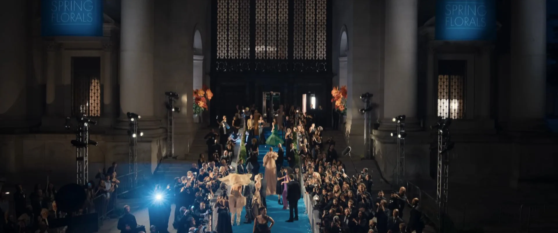 big gala event similar to the met gala with a banner lit up saying 'spring florals' in a scene for the devil wears prada 2